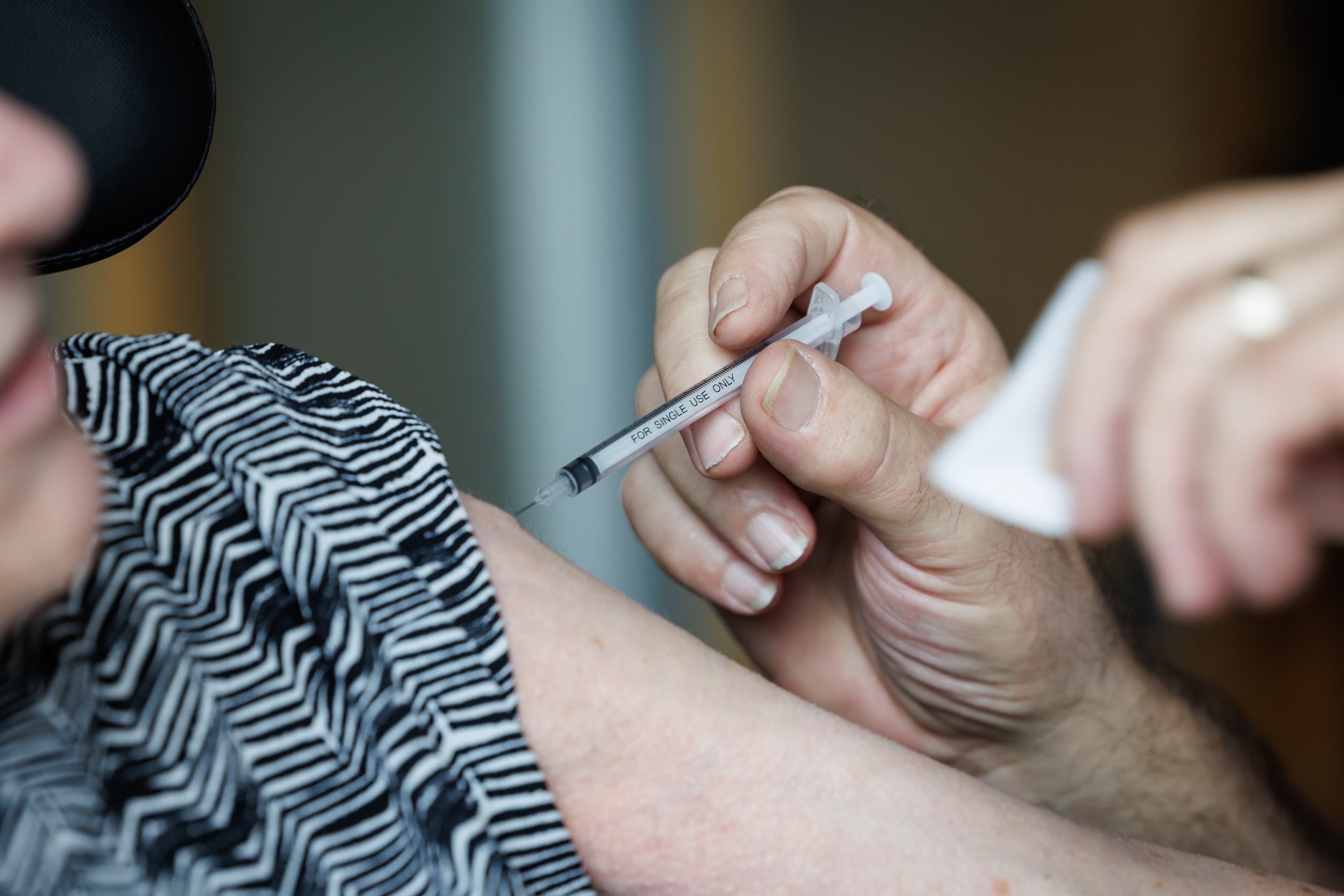 A close-up of a healthcare worker administering a vaccine injection into a patient's arm