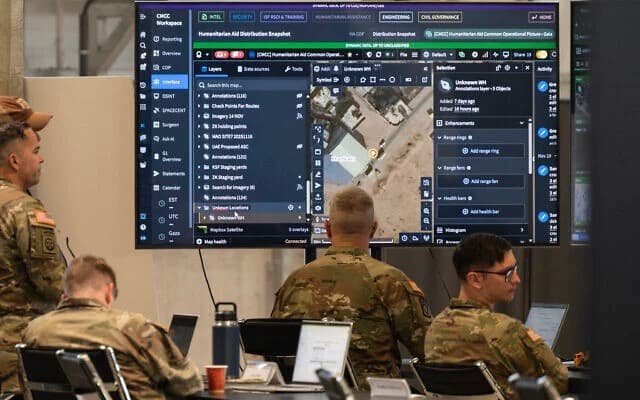 Military personnel viewing data on a large briefing screen in an operations room