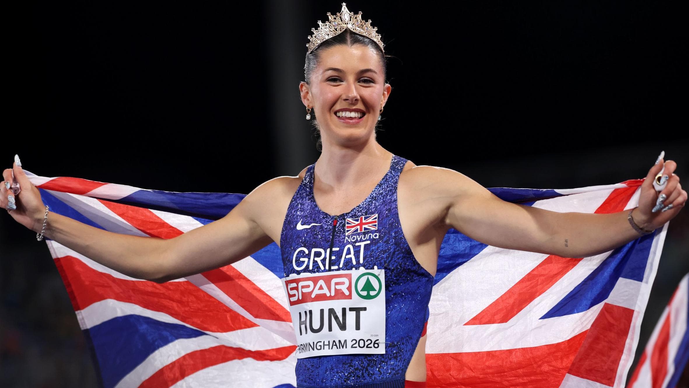 A British sprinter celebrates draped in the Union flag after a major athletics title