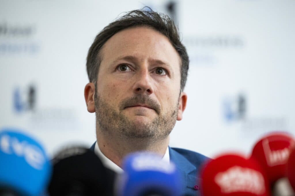 Brussels prosecutor Julien Moinil speaking at a press conference surrounded by microphones