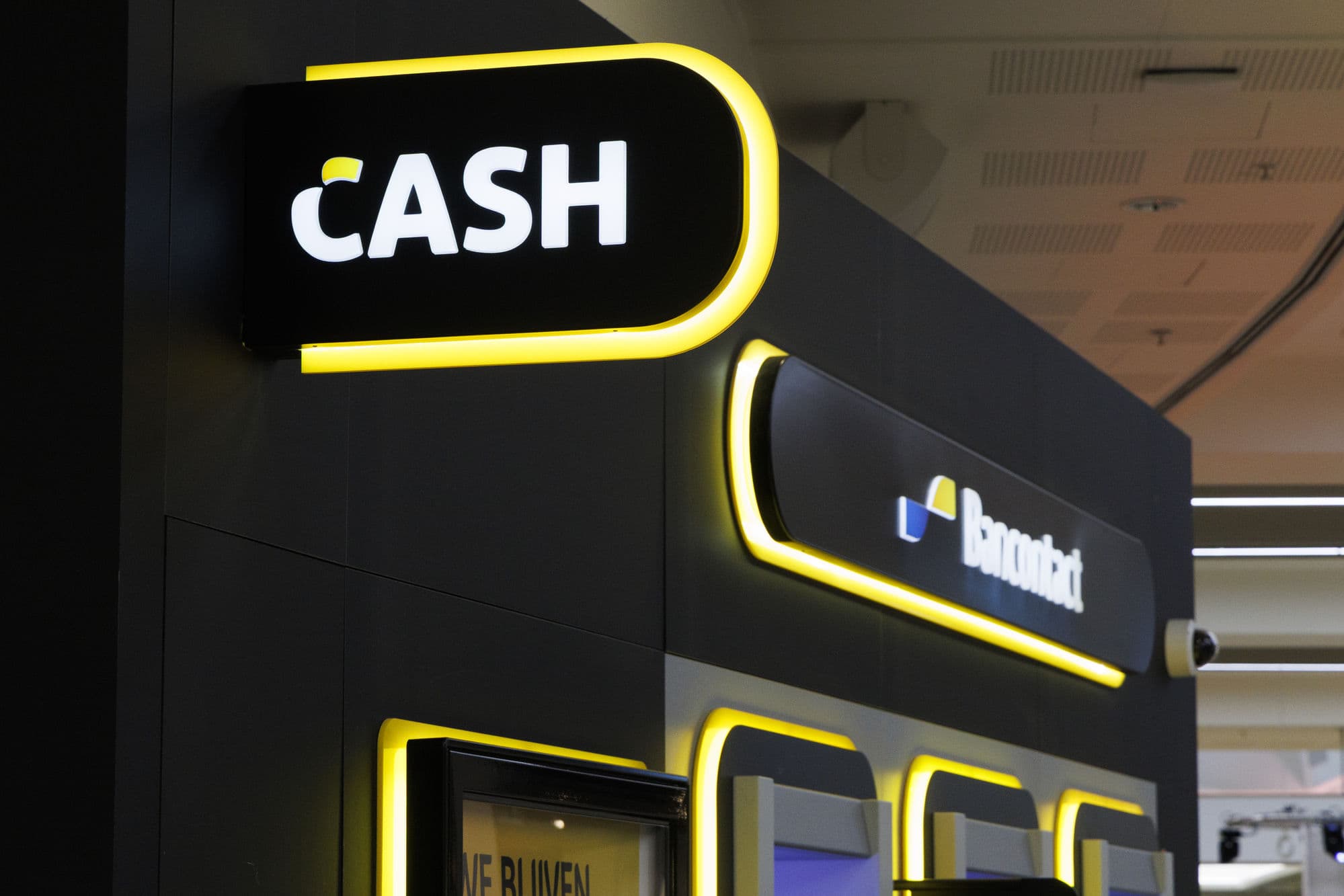 A CASH sign lit up above a Bancontact payment terminal in Belgium