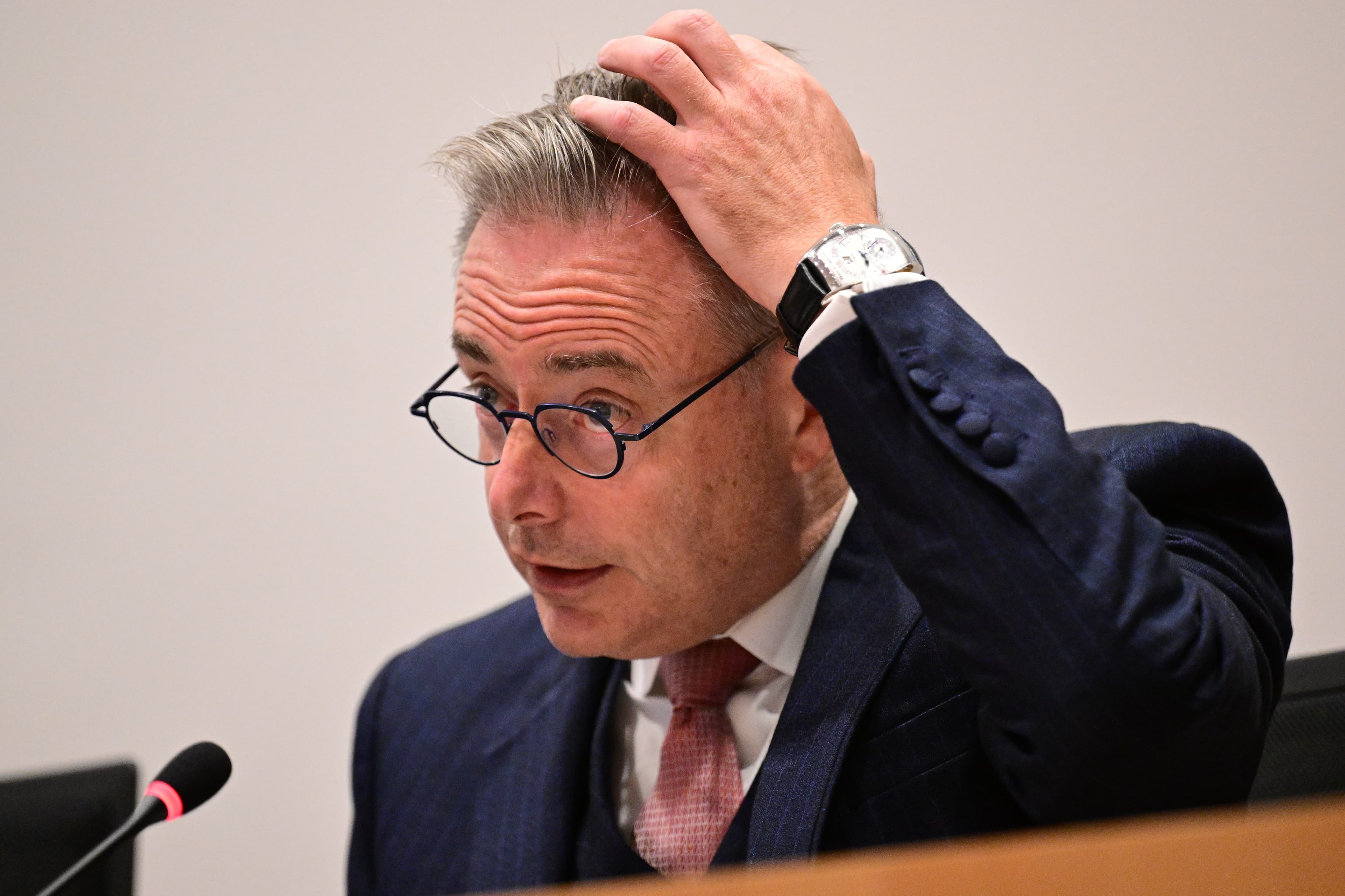 Prime Minister Bart De Wever running a hand through his hair while speaking in parliament