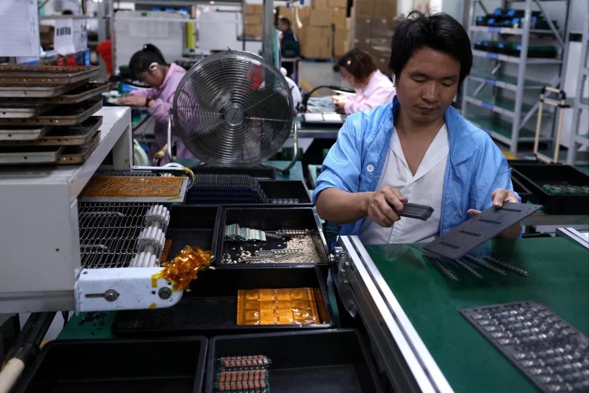 A factory worker assembling electronic components on a production line